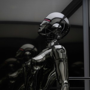A CGI image of dark, gleaming robotic bodies shaped like athletically fit women, with glowing red eyes.